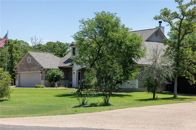 5249 Drake Dr, College Station, TX 77845 - view of property hidden behind natural elements featuring brick siding, a chimney, a front yard, a garage, and roof with shingles