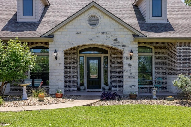 5249 Drake Dr, College Station, TX 77845 - property entrance with roof with shingles, brick siding, stone siding, and a yard