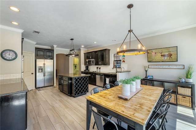 5249 Drake Dr, College Station, TX 77845 - dining area with a chandelier, ornamental molding, light wood finished floors, and recessed lighting