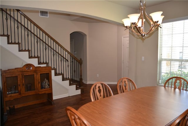 dining room with dark wood-style flooring, visible vents, arched walkways, baseboards, and a chandelier