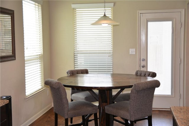 dining area with baseboards and wood finished floors