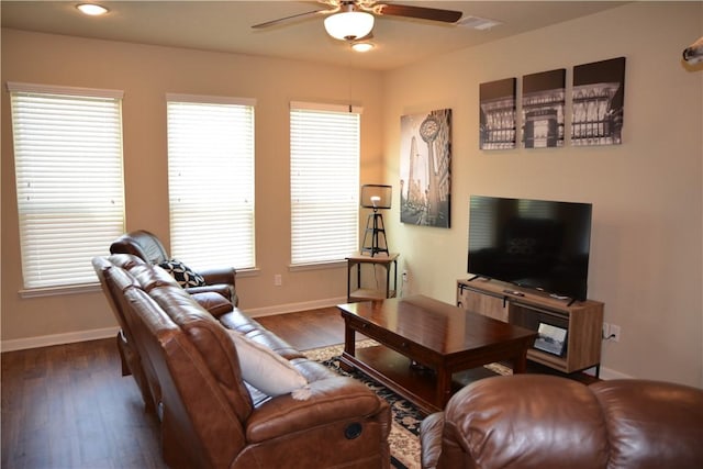 living area featuring baseboards, ceiling fan, wood finished floors, and a healthy amount of sunlight