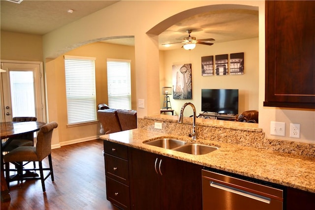 kitchen with dark wood-style flooring, a sink, dishwasher, arched walkways, and open floor plan