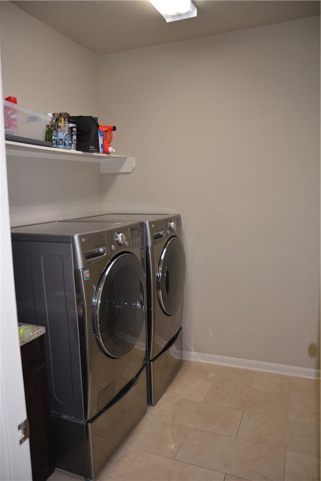 laundry area with baseboards, laundry area, and washer and dryer