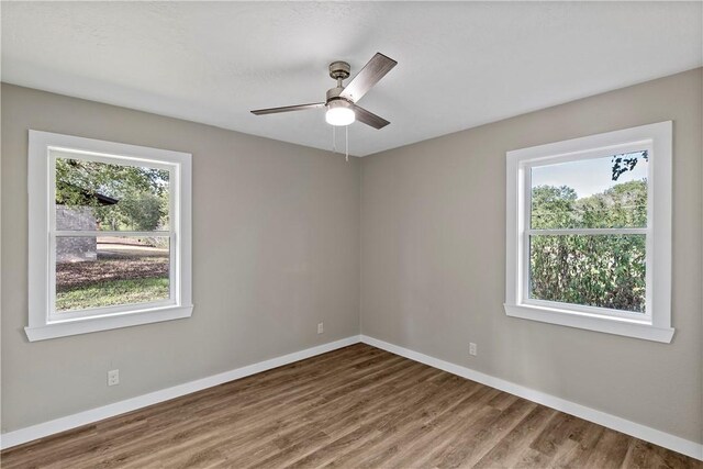 spare room with hardwood / wood-style flooring, plenty of natural light, and ceiling fan