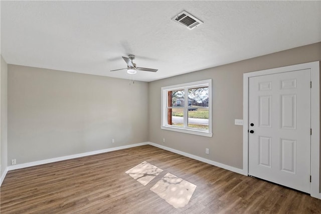 unfurnished room featuring hardwood / wood-style flooring, ceiling fan, and a textured ceiling