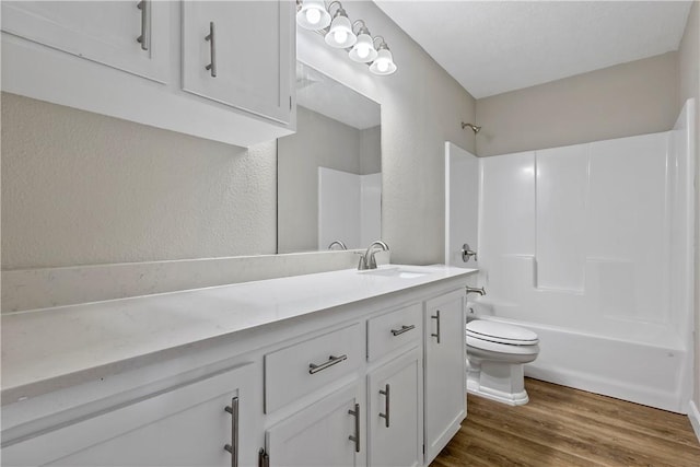 full bathroom featuring shower / washtub combination, hardwood / wood-style floors, vanity, and toilet