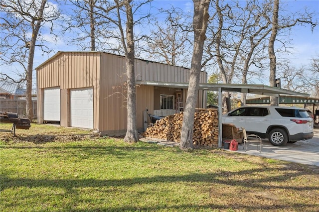 view of outbuilding with a carport, a yard, and a garage