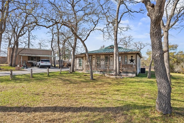 ranch-style house featuring a carport, covered porch, and a front yard