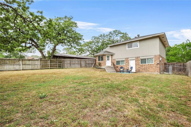 1436 Magnolia Dr, College Station, TX 77840 - rear view of house with brick siding, a fenced backyard, entry steps, and a yard