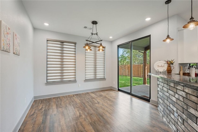 unfurnished dining area with recessed lighting, wood finished floors, and baseboards