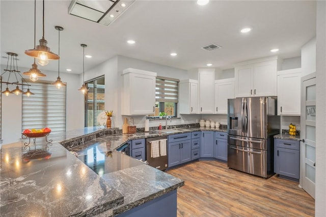 kitchen featuring blue cabinets, stainless steel appliances, white cabinetry, and hanging light fixtures