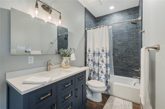 full bath with toilet, shower / bath combo, wood finished floors, and vanity