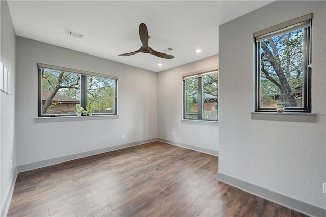 unfurnished room featuring recessed lighting, dark wood-style flooring, a ceiling fan, visible vents, and baseboards