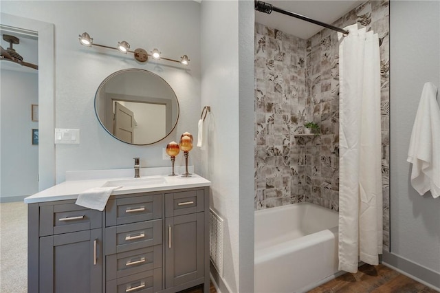 bathroom with wood finished floors, shower / bath combination with curtain, and vanity