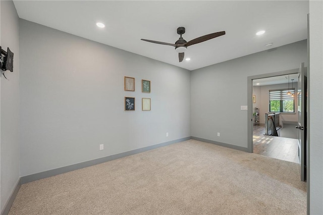 empty room featuring recessed lighting, baseboards, and light colored carpet