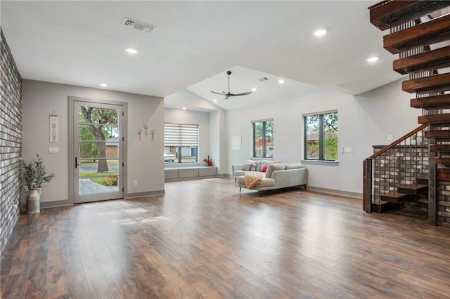 unfurnished living room featuring dark wood-style flooring, recessed lighting, visible vents, baseboards, and stairs