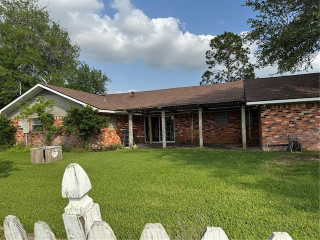 back of house featuring a yard and brick siding