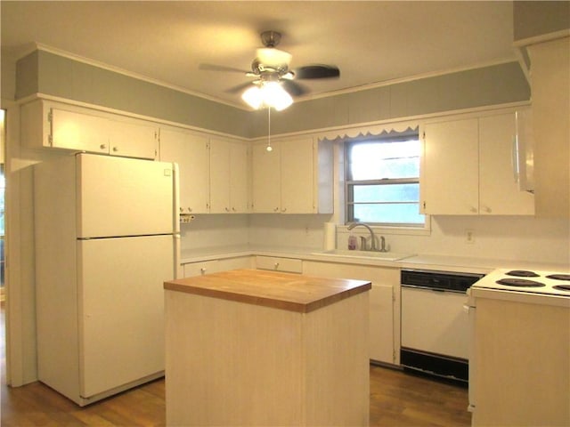 kitchen with butcher block countertops, white appliances, crown molding, and a sink