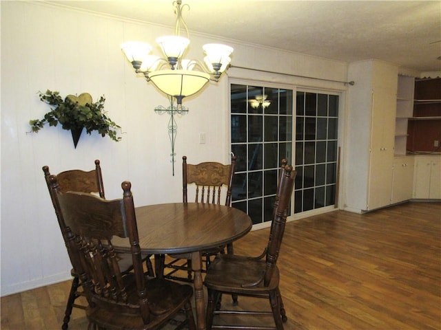 dining room featuring wood finished floors, an inviting chandelier, and ornamental molding
