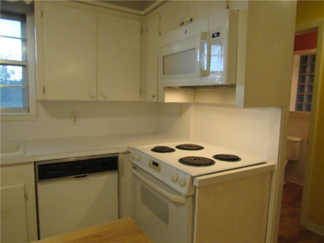 kitchen featuring light countertops, white cabinetry, and white appliances