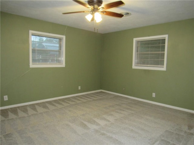 carpeted empty room with baseboards and ceiling fan