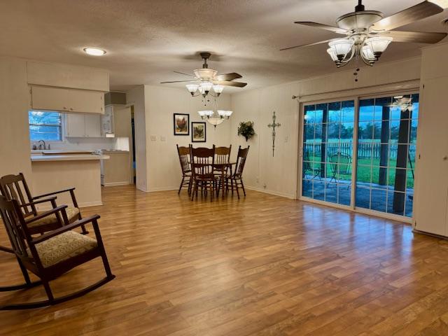 dining area featuring baseboards, light wood-type flooring, and ceiling fan