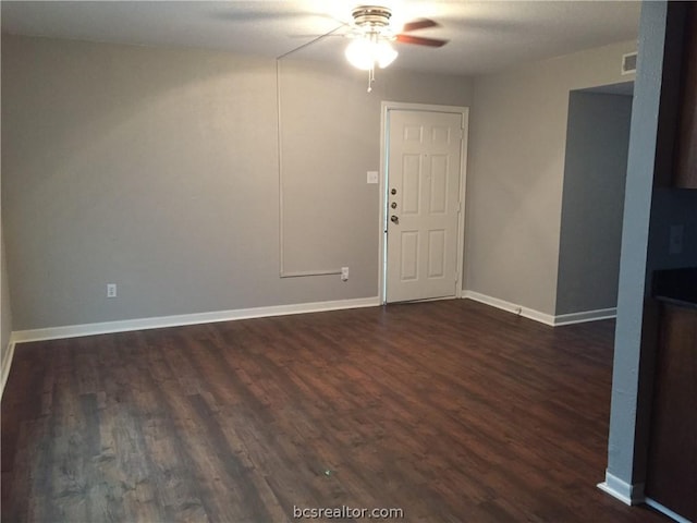 empty room with ceiling fan and dark wood-type flooring