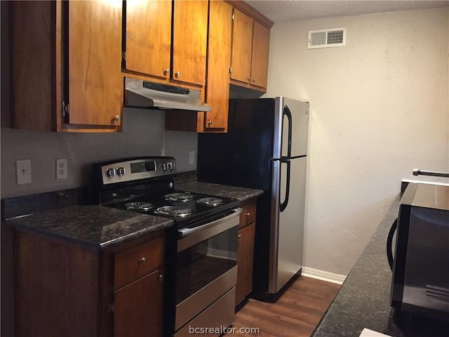 kitchen featuring a textured ceiling, dark stone counters, stainless steel electric range oven, and dark wood-type flooring