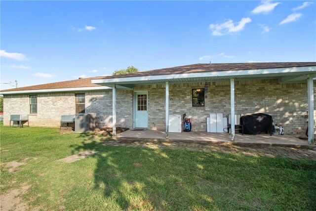9777 Deer Trail Run, Hearne, TX 77859 - rear view of house with brick siding, a yard, and a patio area