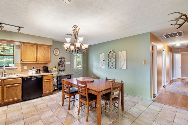 9777 Deer Trail Run, Hearne, TX 77859 - dining space featuring a chandelier, a textured ceiling, and light tile patterned floors