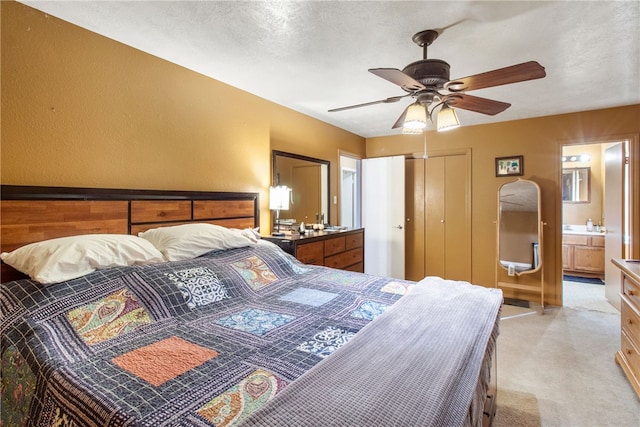 9777 Deer Trail Run, Hearne, TX 77859 - bedroom with light carpet, connected bathroom, a closet, ceiling fan, and a textured ceiling