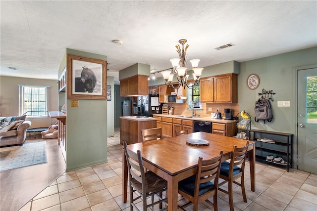 9777 Deer Trail Run, Hearne, TX 77859 - dining space with a chandelier, healthy amount of natural light, light tile patterned floors, and a textured ceiling