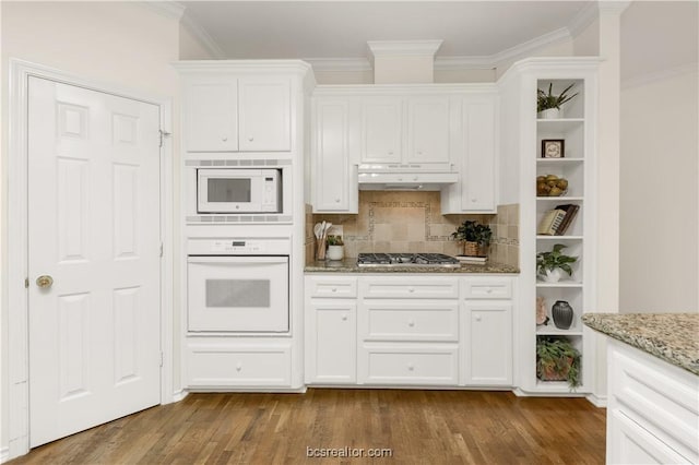 kitchen with dark wood-style floors, crown molding, white cabinets, white appliances, and under cabinet range hood