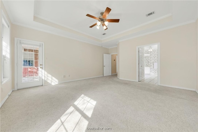 unfurnished bedroom featuring ornamental molding, carpet floors, a tray ceiling, and baseboards