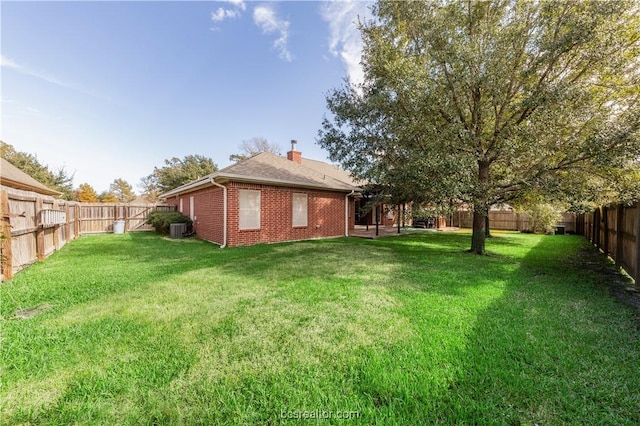 view of yard featuring a fenced backyard and central AC