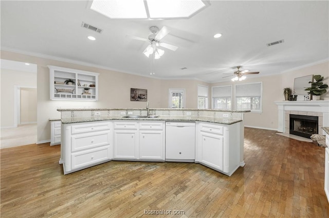 kitchen with a sink, crown molding, visible vents, and dishwasher