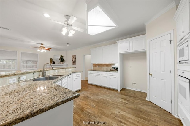 kitchen featuring tasteful backsplash, visible vents, ornamental molding, a sink, and white appliances