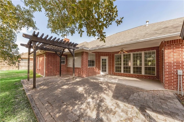 back of house featuring brick siding, a patio, a lawn, fence, and a pergola