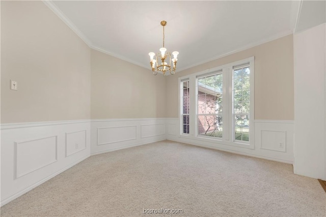 carpeted spare room with a wainscoted wall, ornamental molding, and a notable chandelier