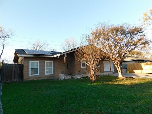 view of front of property featuring solar panels, a garage, and a front lawn