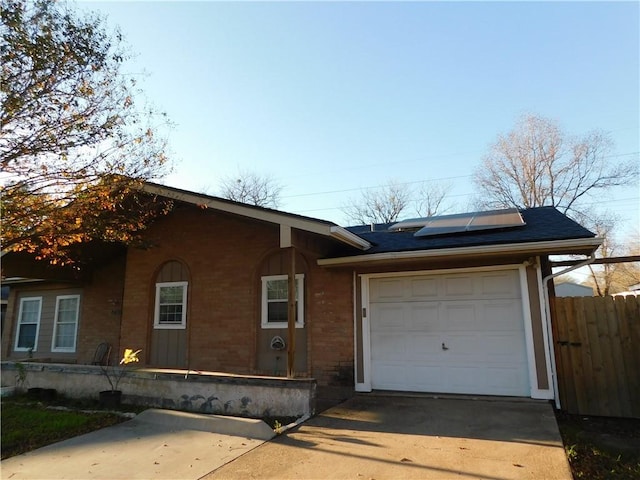 ranch-style home featuring solar panels and a garage