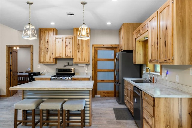 3205 County Road 308, Caldwell, TX 77836 - kitchen with stainless steel appliances, a sink, a breakfast bar, wood finished floors, and pendant lighting