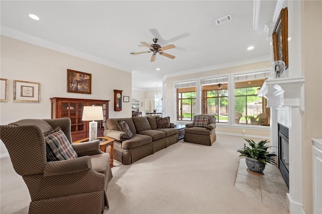 living room featuring crown molding, light colored carpet, a ceiling fan, a fireplace with flush hearth, and visible vents