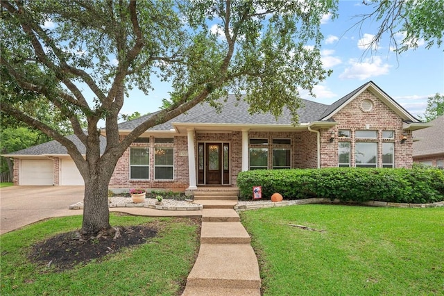 single story home with a front lawn, roof with shingles, brick siding, concrete driveway, and an attached garage
