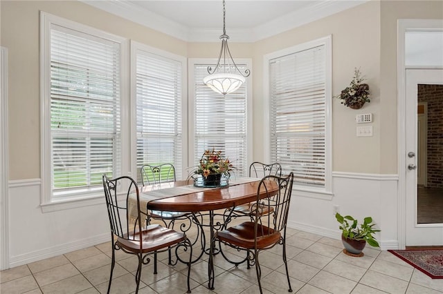 dining space featuring baseboards, ornamental molding, and light tile patterned flooring