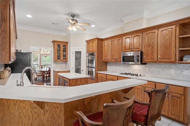 kitchen featuring open shelves, a peninsula, ceiling fan, light countertops, and stainless steel appliances