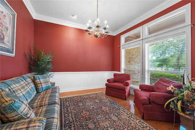 living area with a notable chandelier, ornamental molding, and wood finished floors
