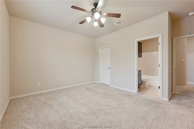 128 Kimber Ln, College Station, TX 77845 - unfurnished bedroom featuring light carpet, baseboards, connected bathroom, and ceiling fan