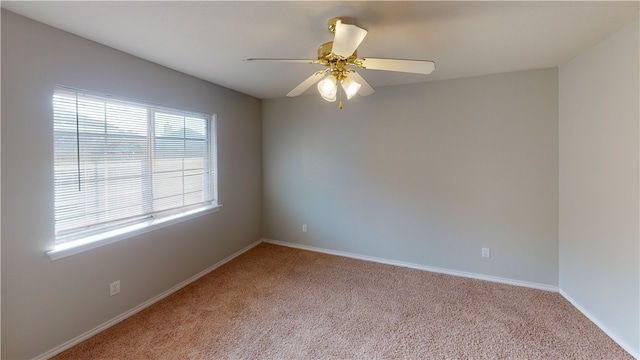 spare room featuring light colored carpet and ceiling fan